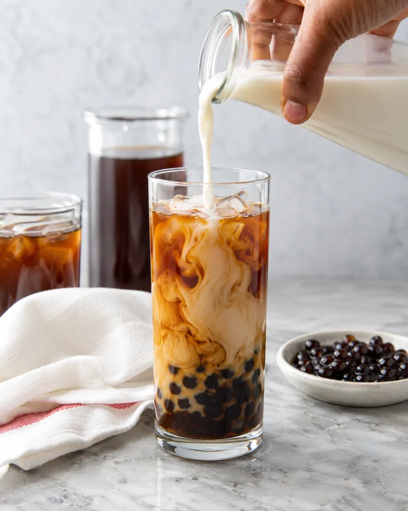 Infografía con seis pasos para preparar una bebida de té con leche, hielo y perlas de tapioca en casa.