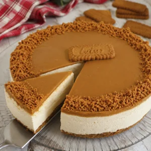 Tarta de queso Lotus sin horno 7 Tarta de queso Lotus sin horno con una porción sobre una pala y borde de galleta triturada.