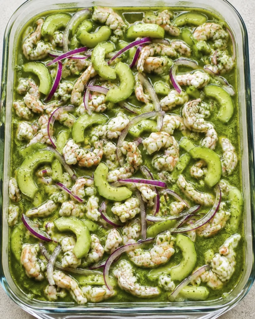 Refractario con aguachile verde de camarón servido con pepino, cebolla morada y salsa de cilantro.