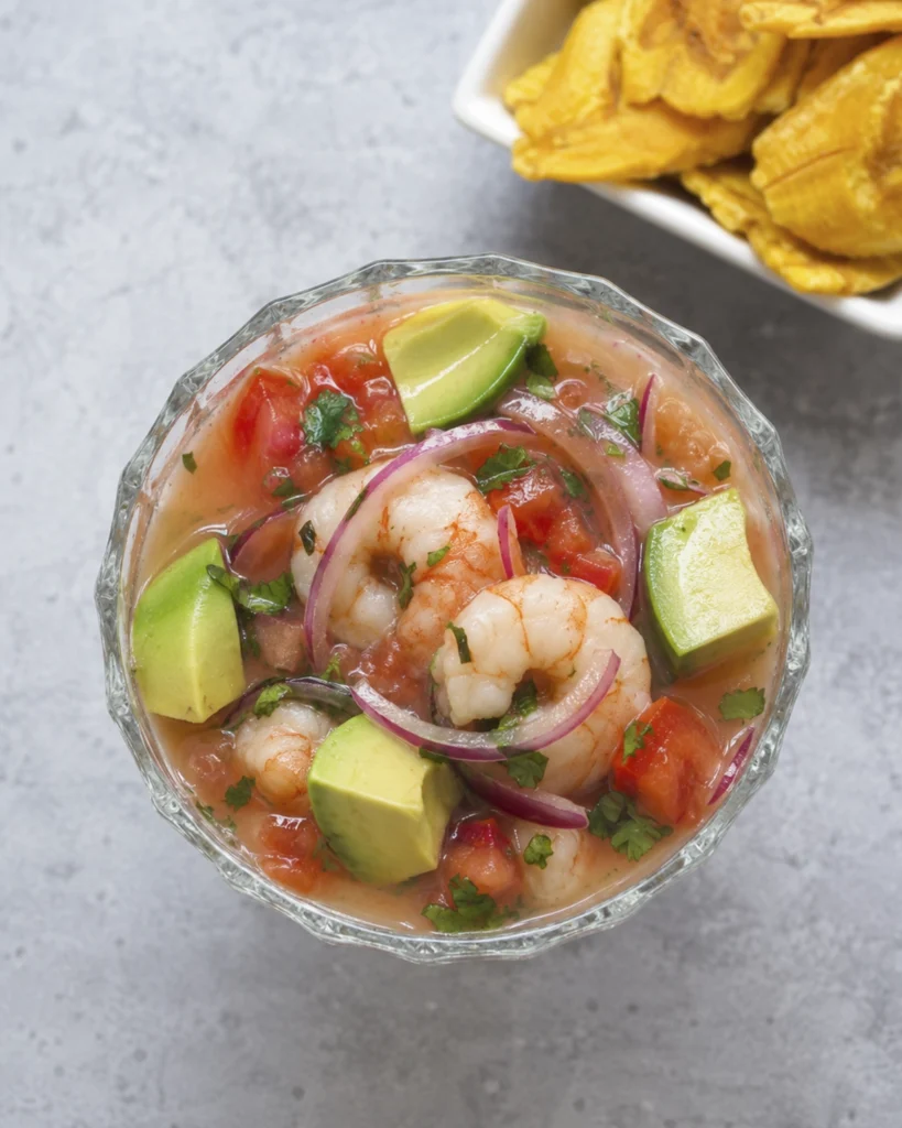 Ceviche de camarones con yuca 5 Ceviche de camarones con aguacate, tomate, cebolla morada, cilantro y chifles dorados al fondo.