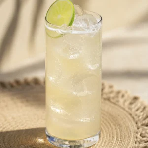 Primer plano de un coctel Paloma con tequila frío con cubos de hielo y lima fresca.